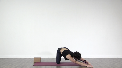 Yoga teacher performing yoga posture on green yoga mat on white background