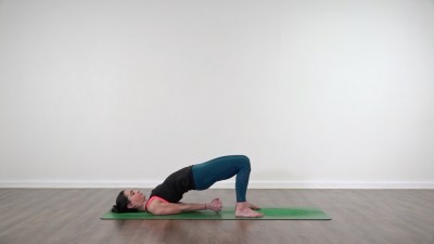 Yoga teacher performing yoga posture on green yoga mat on white background