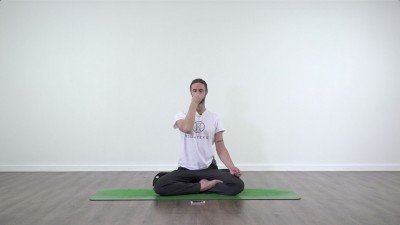 Yoga teacher performing yoga posture on green yoga mat on white background