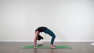 Yoga teacher performing yoga posture on green yoga mat on white background
